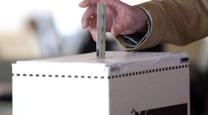 A man puts a ballot in a box