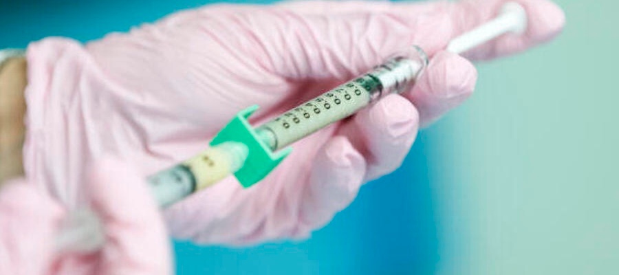 A syringe being filled with vaccine